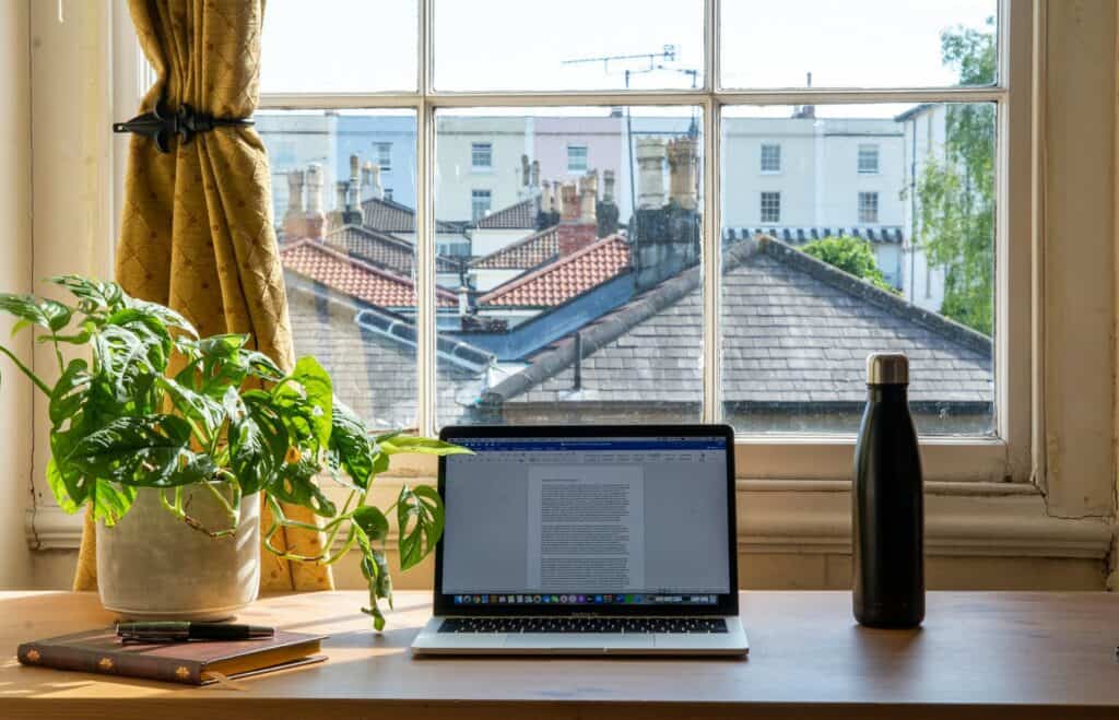 An image of a laptop placed on a desk by a window, promoting 'Secrets of Sequencing: Boost Sales with Magnetic E-Commerce Emails!'.