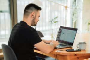 Does Email Marketing Still Work in 2024? A man sitting at a table with a laptop, focused on the screen.